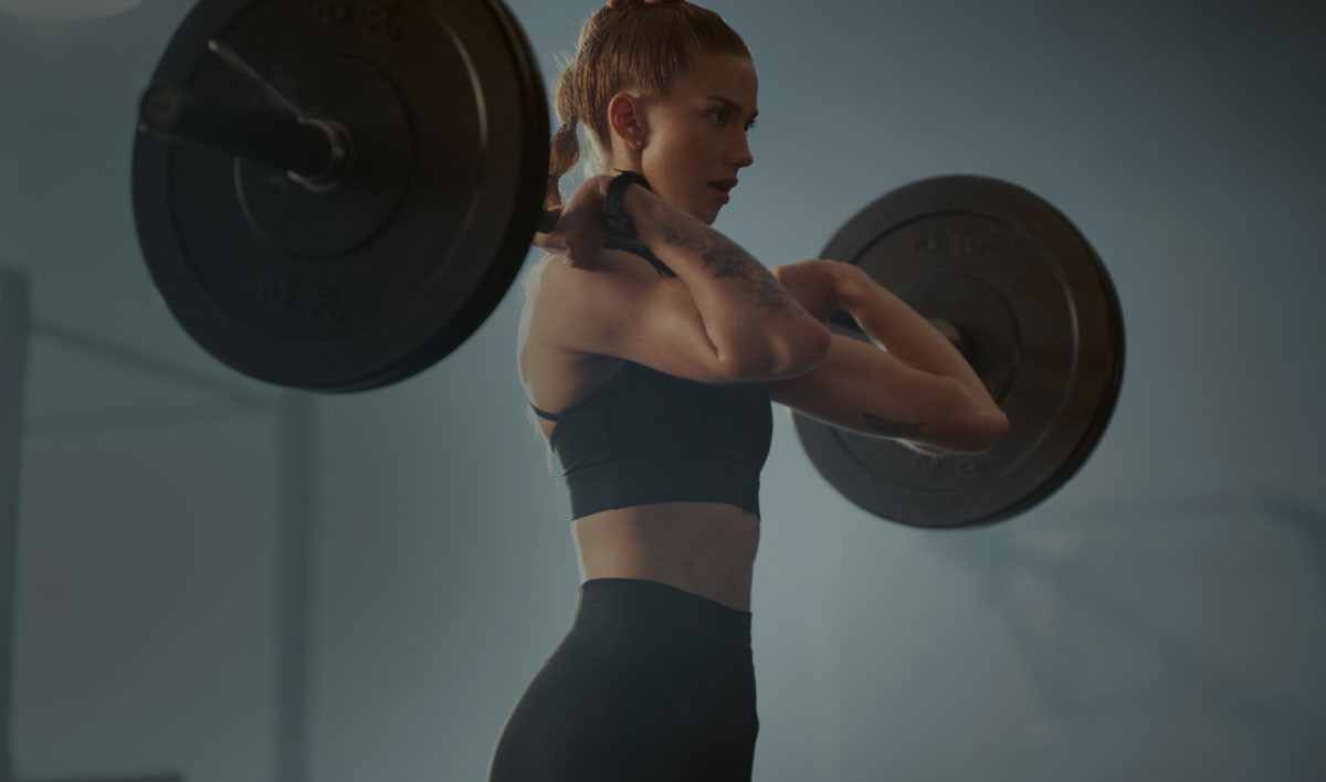 Woman lifting a barbell during a strength session at Bridge Fitness